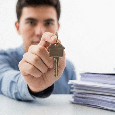 Person holding a house-shaped key, symbolizing property and agreements